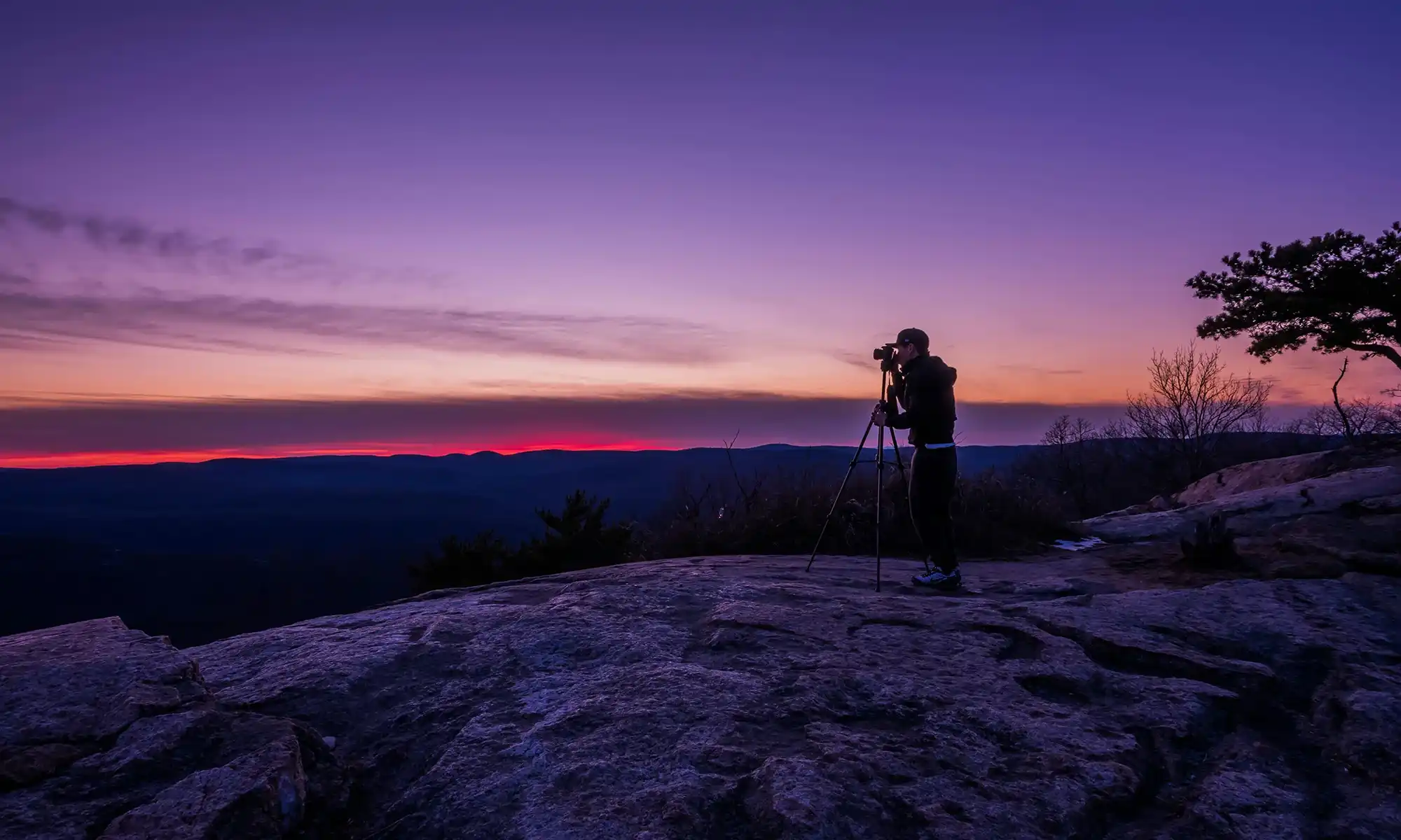 A person looking out over a Colorado mountain landscape at dusk