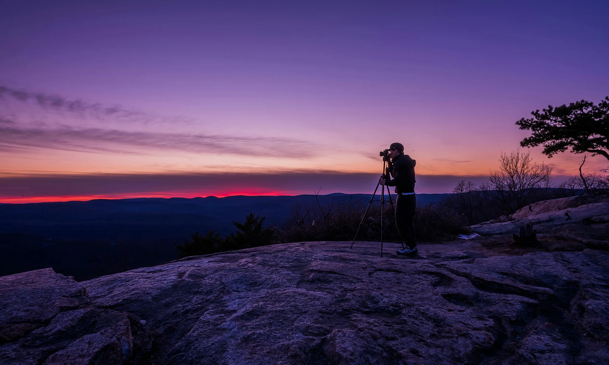 A person looking out over a Colorado mountain landscape at dusk