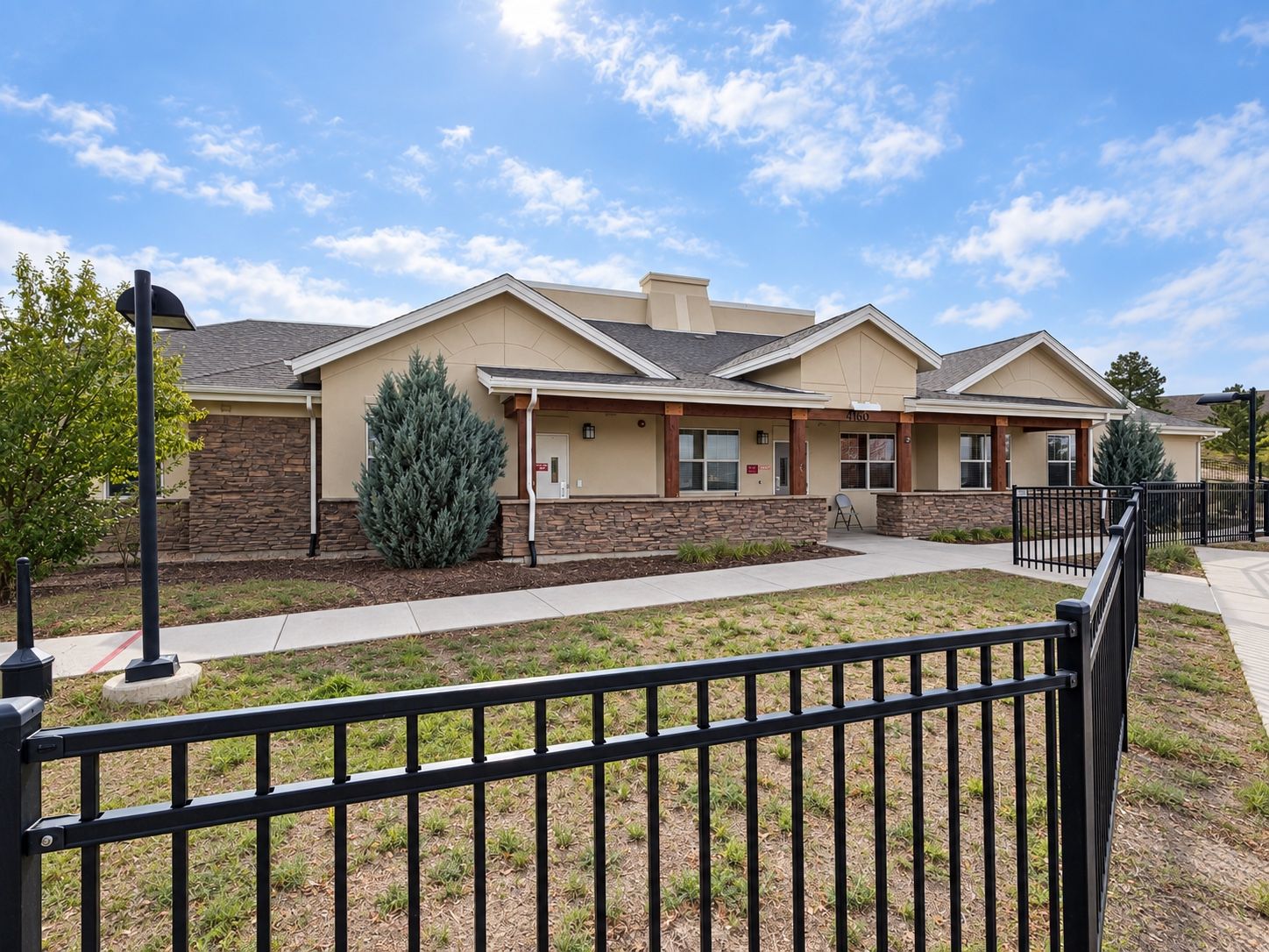 A Spring Grove Recovery building in Colorado Springs, Colorado, seen from the walk with its covered porch and stone base