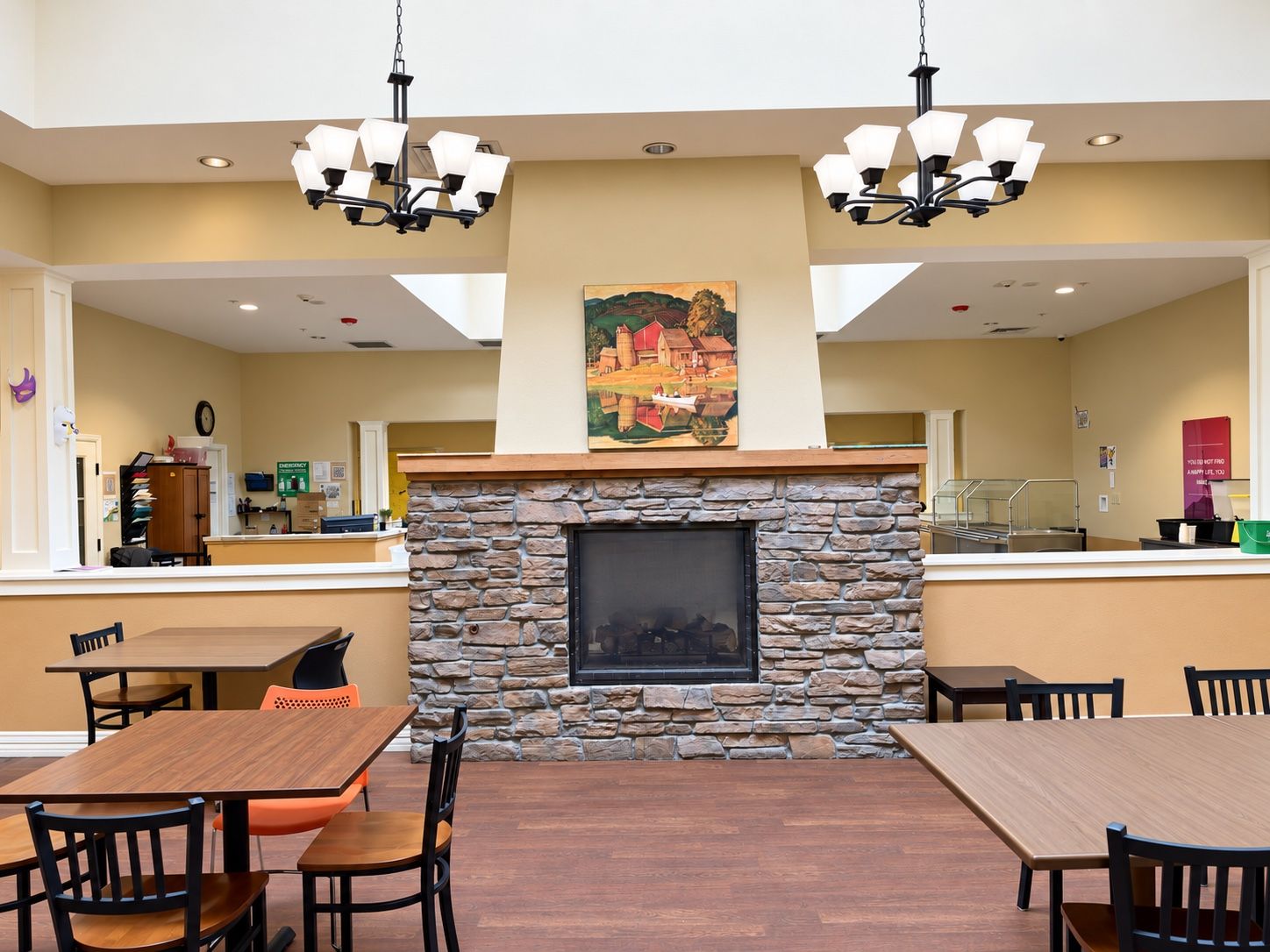 A community room at Spring Grove Recovery in Colorado Springs, Colorado, with dining tables and a stone fireplace