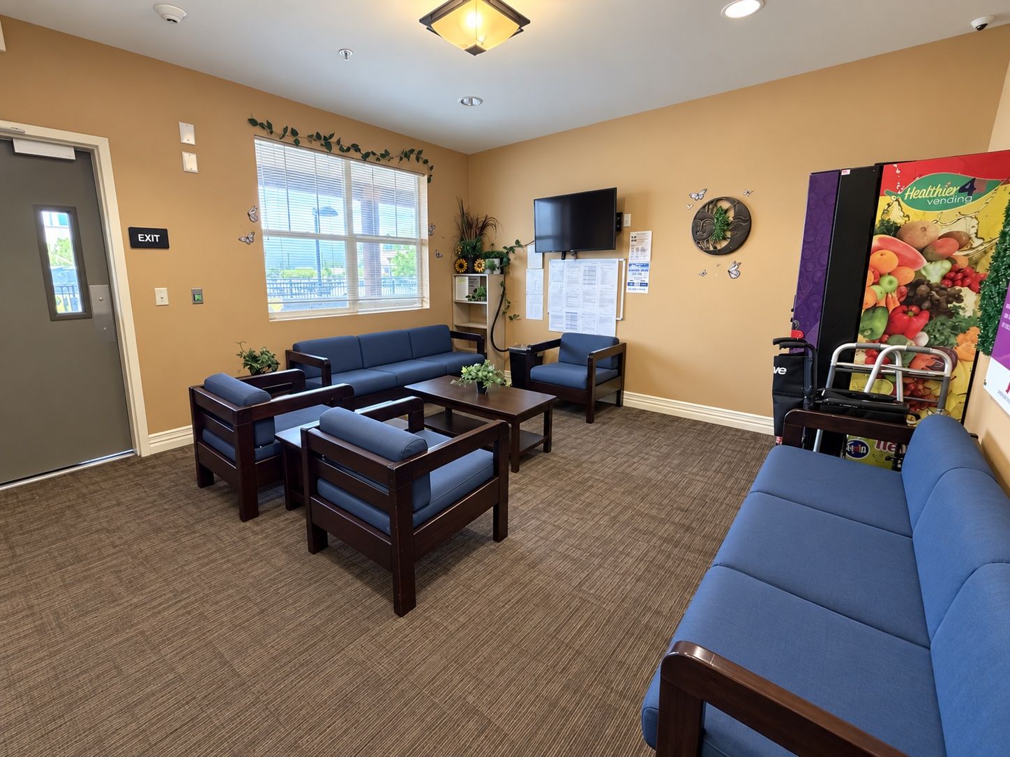 A lounge at Spring Grove Recovery in Colorado Springs, Colorado, with sofas, armchairs, a television and vending machines