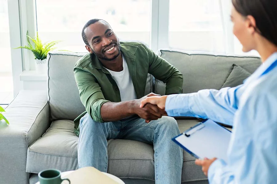 a man shakes the hand of his addiction treatment specialist