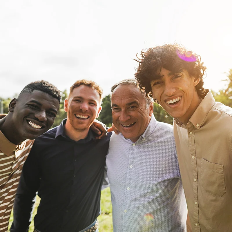 a diverse group of men embraces for a photo opportunity
