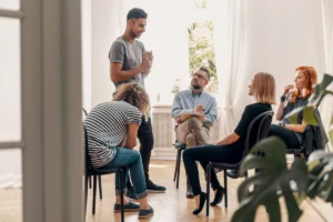 Man standing up in group therapy session