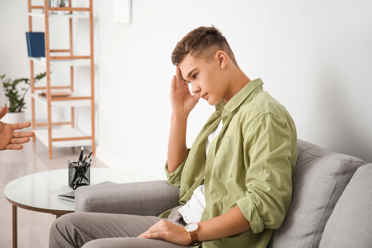 Man holding head on couch