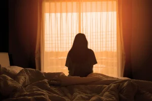 Silhouette of woman in front of a sun lit window